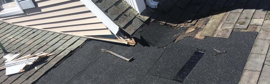 Expert roof leak repair on East End, Long Island, NY, showing a damaged roof section with shingles and flashing.
