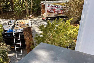 A worker's tools on a flat roof during a roofing repair project in Long Island, NY.