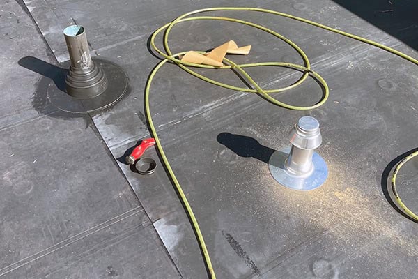 Roofing and chimney flashing installation on a flat roof in Long Island, NY.
