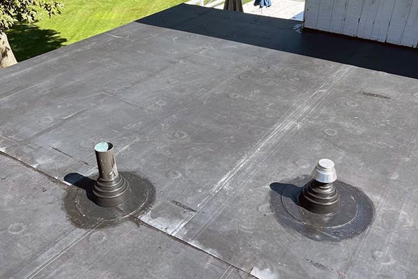 Roofing and chimney vent installation on a flat commercial roof in Long Island, NY.