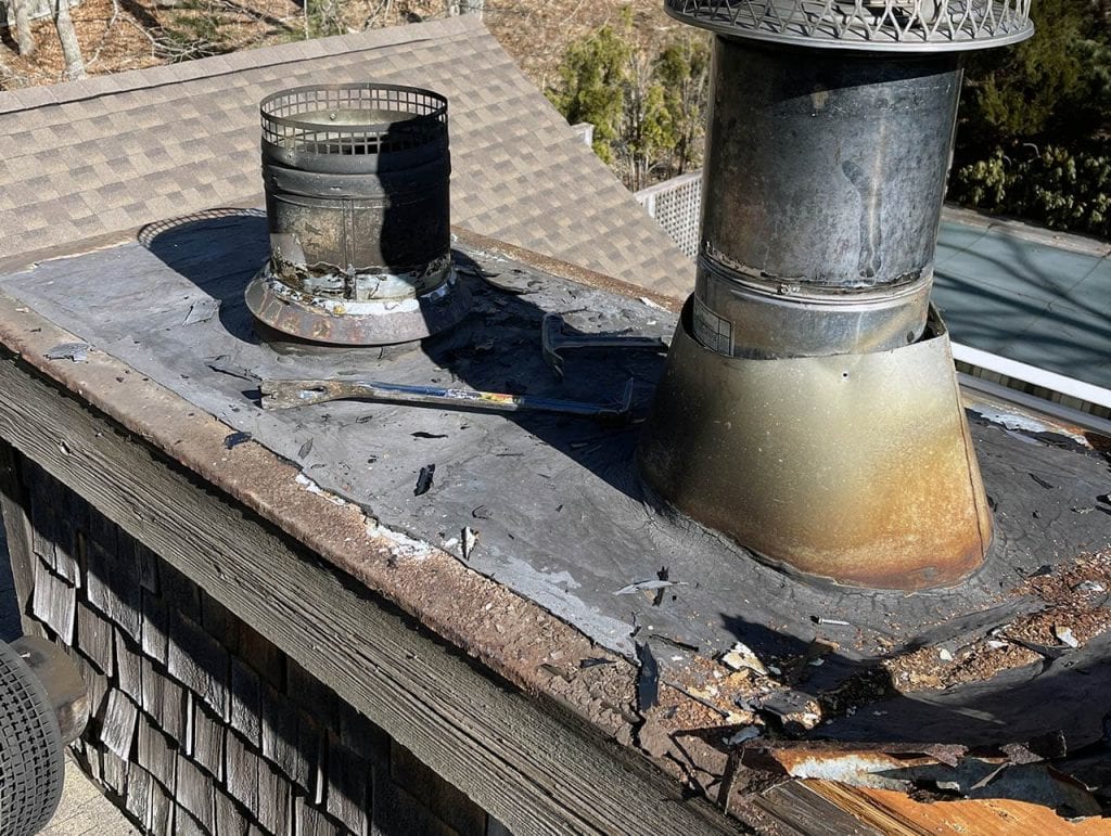 Chimney vent and roof flashing damage on a residential roof in Long Island, NY.
