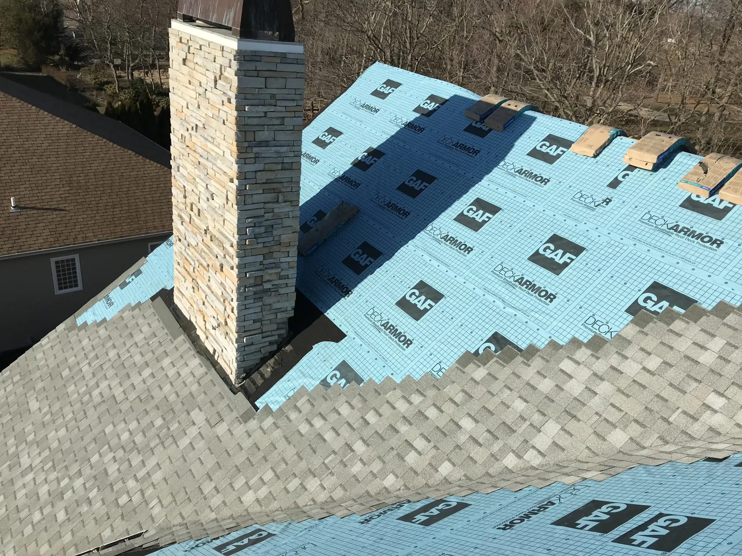 GAF shingle roof installation with stone chimney flashing Long Island